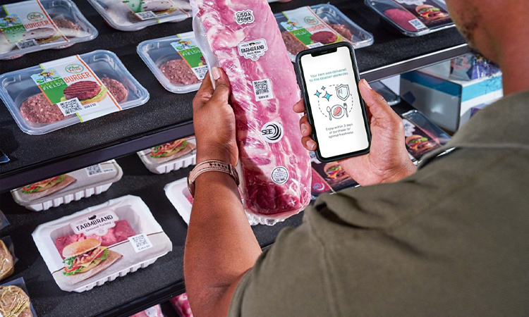 Er scannt mit seinem Mobiltelefon den RFID-Code auf dem Produkt, um die Herkunft des Lebensmittels zu überprüfen.