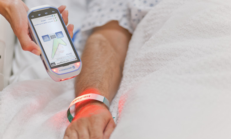Die Krankenschwester kann das RFID-Armband an der Hand des Patienten scannen, um seine Daten zu erfahren.