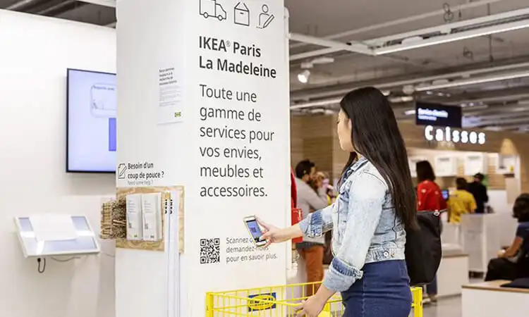 Sie scannt den QR-Code an der Wand, um die Produkteinführung des Einkaufszentrums zu erhalten