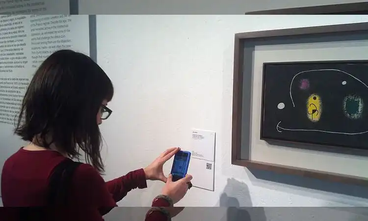 this woman is testing the museum's qr code to see if it works