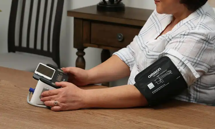 Она использует устройство IoMT дома, чтобы проверить свое кровяное давление.